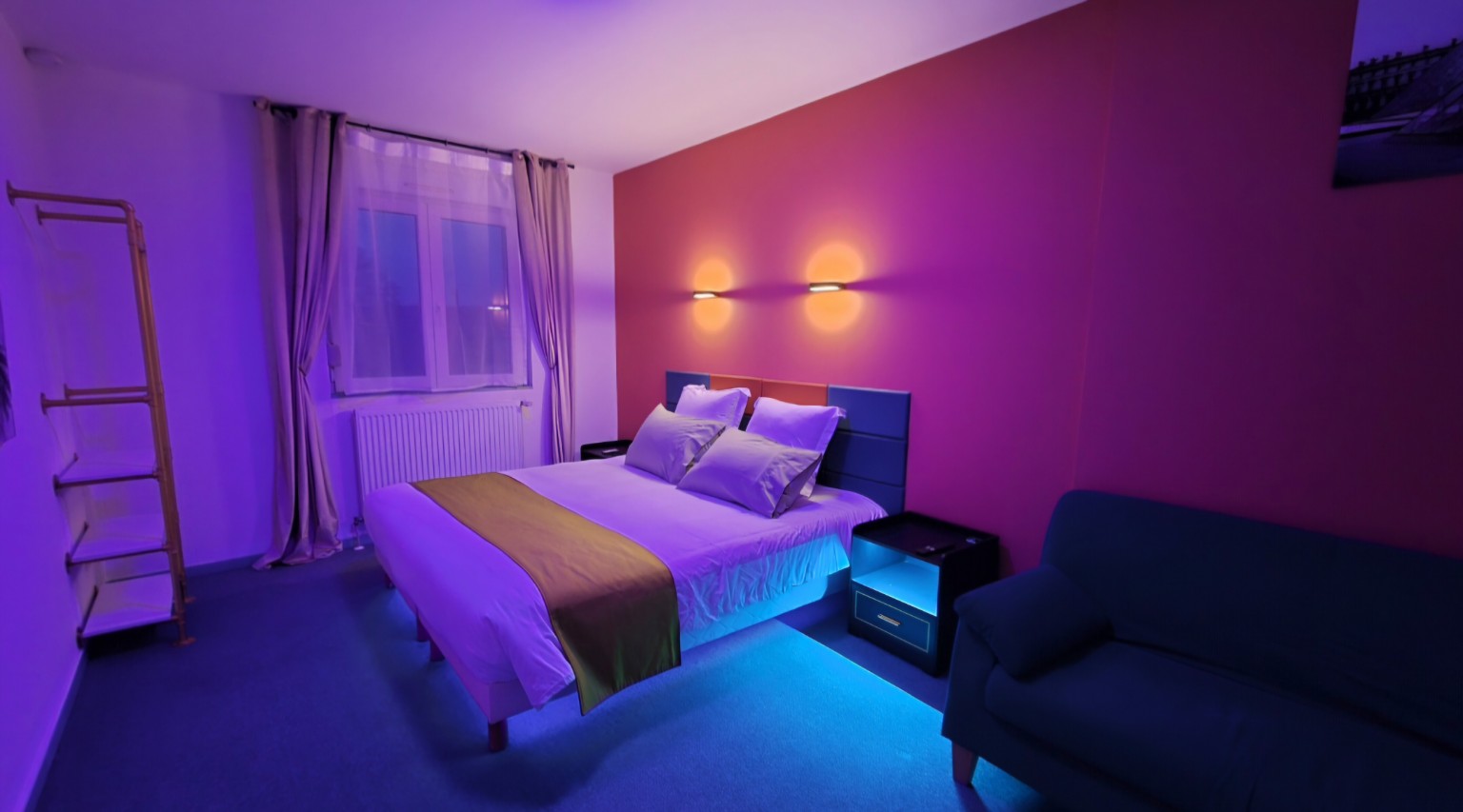 Lit king size de l’Appartement 2 avec éclairage d’ambiance violet