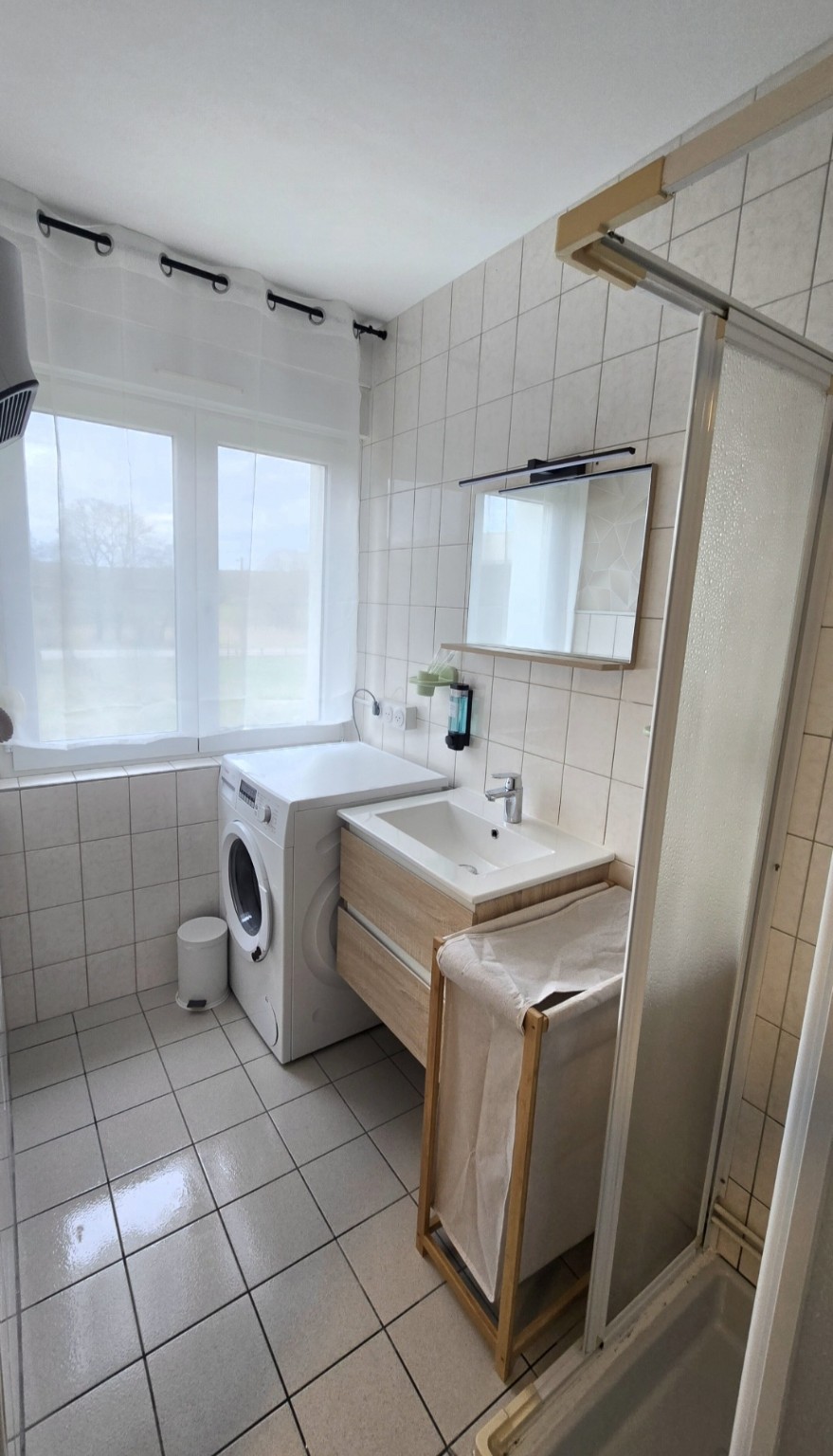Salle d’eau privative de l’Appartement 3 avec douche, vasque et lave-linge