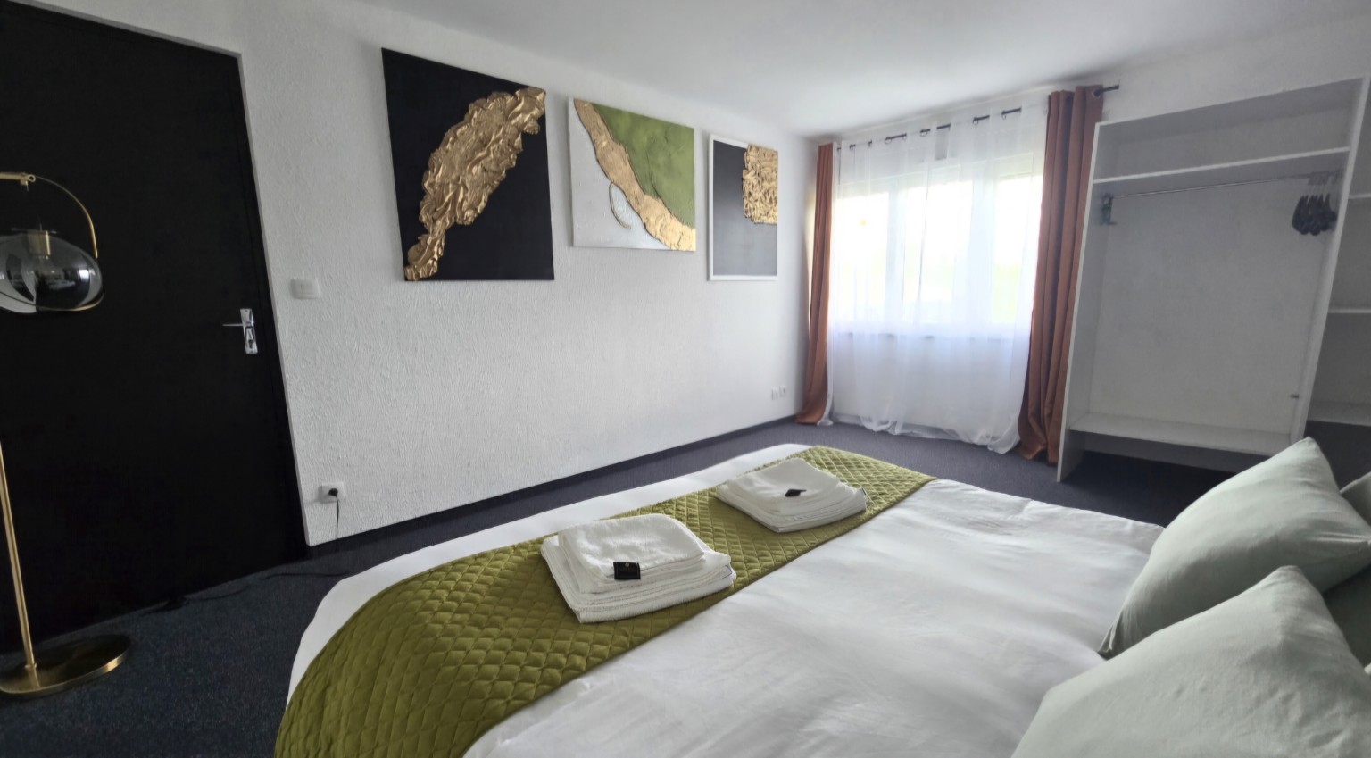 Chambre lumineuse de l’Appartement 5 avec dressing ouvert