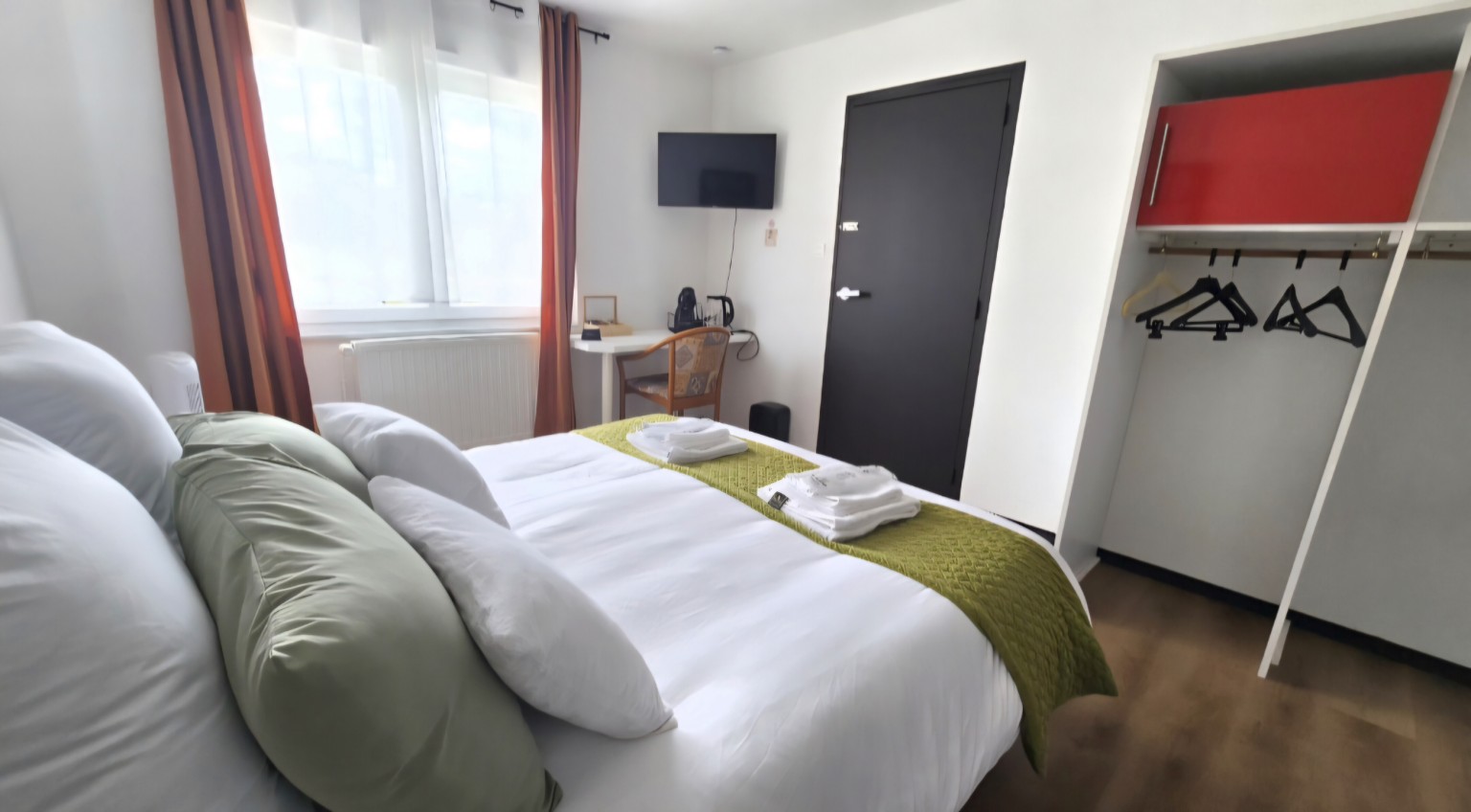Lit queen size, télévision connectée et espace de rangement de la Chambre 5